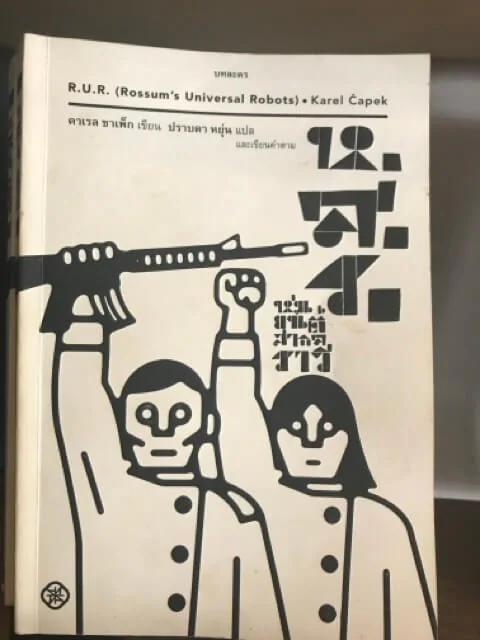 Thai edition of Karel Capek's R.U.R., the cover showing two robots in black and white, one holding a rifle.